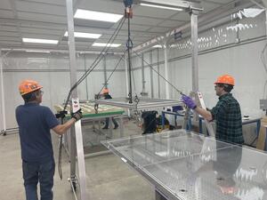 People lifting a large CRP in clean room tent.